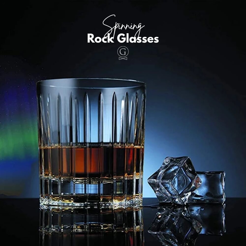 Glass with liquid and ice cube on a reflective surface with 'Spinning Rock Glasses' branding.